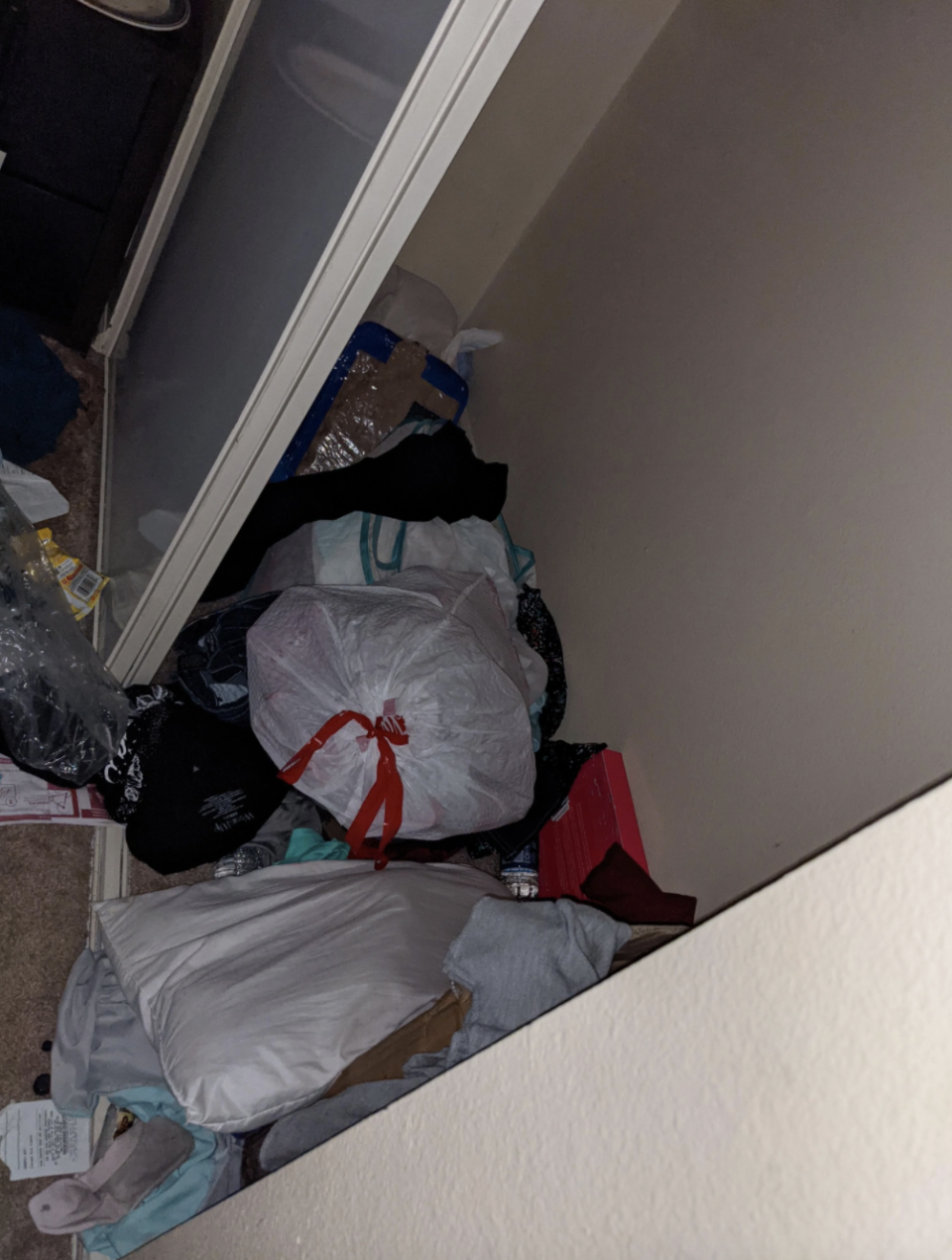 Bad roomie's room, dirty with used water bottles, soda bottles, and trash bags