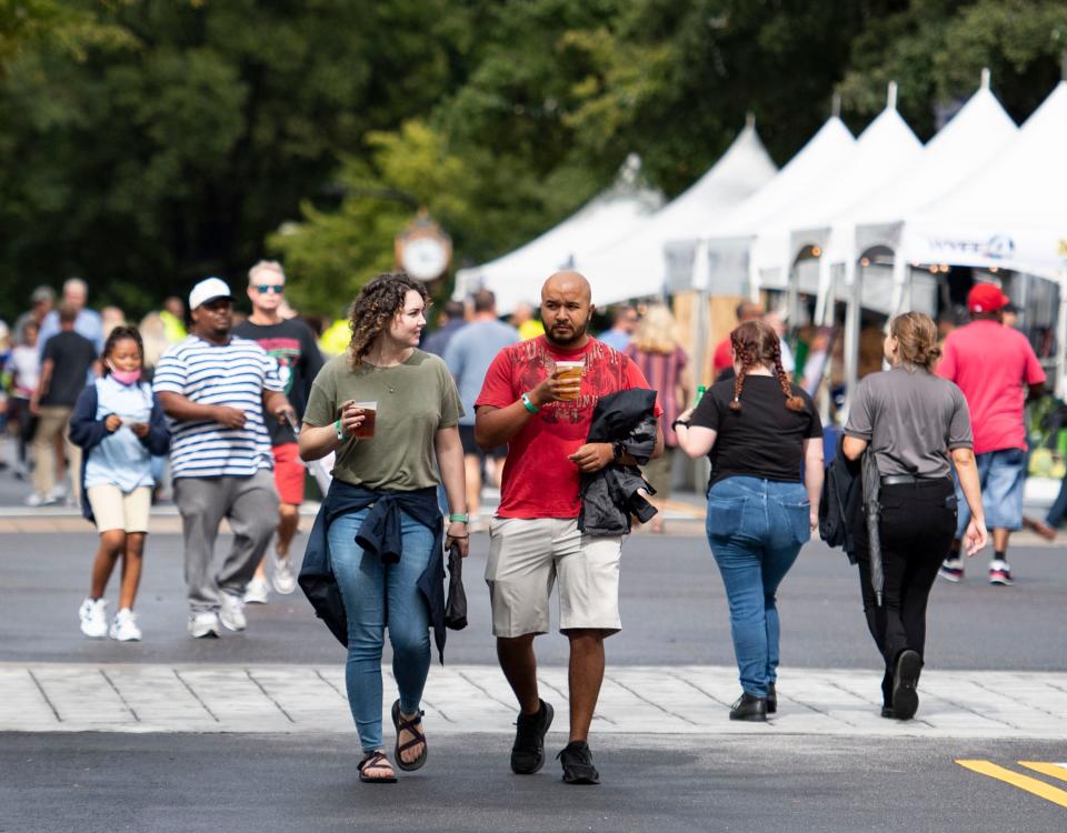 Meredith King, 29, and her boyfriend Franklin Medina, 30, both of Georgia, walk down the streets filled vendors during Fall for Greenville on Friday, October 8, 2021