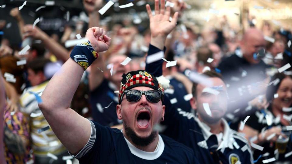 A Scotland fan in shades cheers