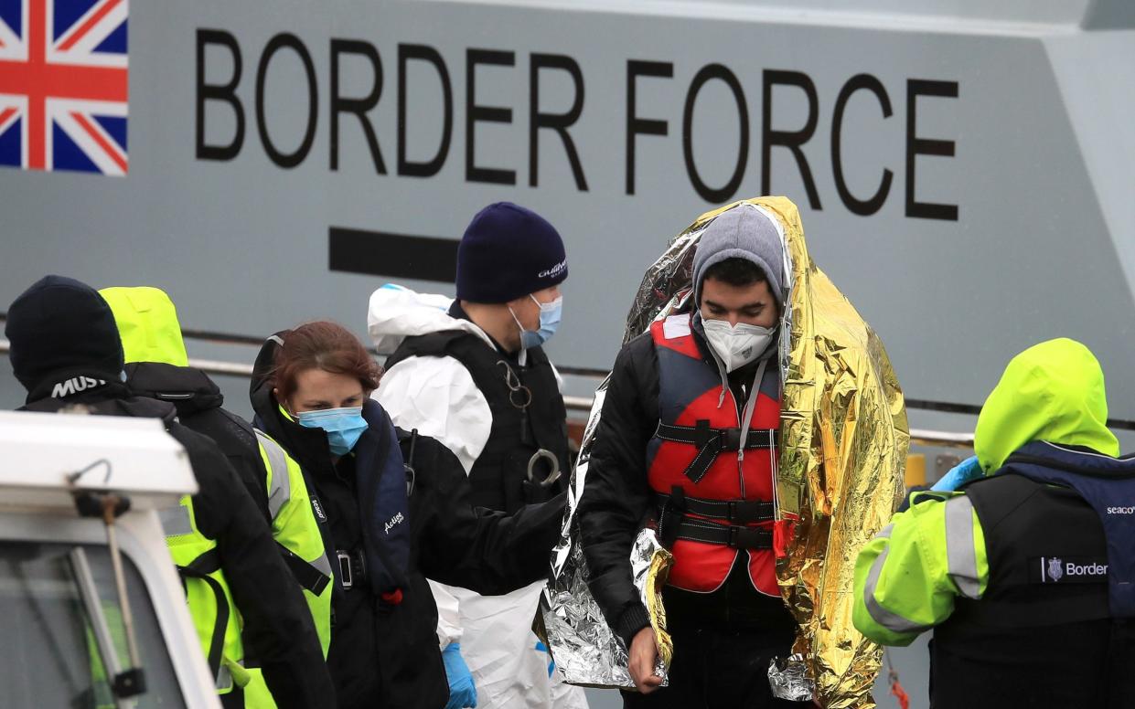 A man is helped by a Border Force officer as a group of people thought to be migrants are brought in to Dover, Kent, onboard a Border Force vessel following a small boat incident in the Channel. - Gareth Fuller/PA