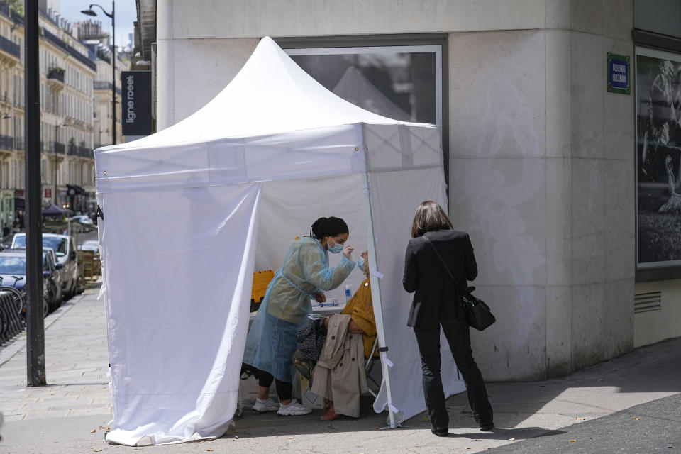 A medical technician administers nasal swabs at a mobile testing site in Paris, Monday, July 12, 2021. France's President Emmanuel Macron is hosting a top-level virus security meeting Monday morning and then giving a televised speech Monday evening, the kind of solemn speech he's given at each turning point in France's virus epidemic.(AP Photo/Michel Euler)