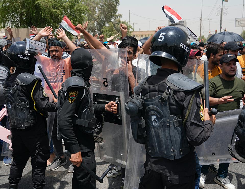 FILE - Security forces stand guard while protesters chant slogans near the Iraq's parliament in Baghdad, Iraq, Tuesday, June 7, 2022. More than seven months after national elections, Iraq still doesn't have a government. Driven by cutthroat competition for power and resources between elites, there is no clear way out of the unprecedented impasse. (AP Photo/Hadi Mizban, File)