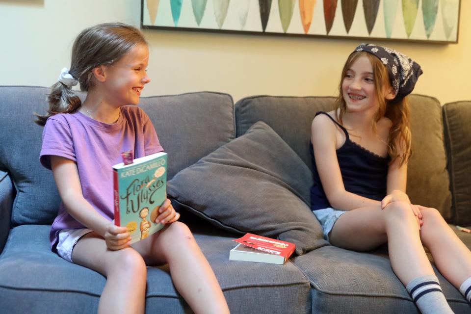 High Point students Ava Lee (left) and Charlotte McCullough, both 9, laugh together as Ava shares her favorite parts in Kate DiCamillo's "Flora & Ulysses" book during a book club meeting June 23 in Gahanna.