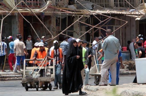 Iraqis gather at the site of a blast in Baghdad on Thursday. A spate of bombings in Baghdad killed at least 16 people and wounded dozens more, shattering a relative calm with the capital's deadliest violence in weeks