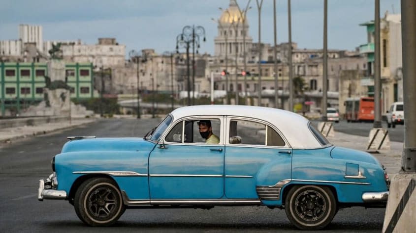 A man drives down a street in Havana, Cuba.