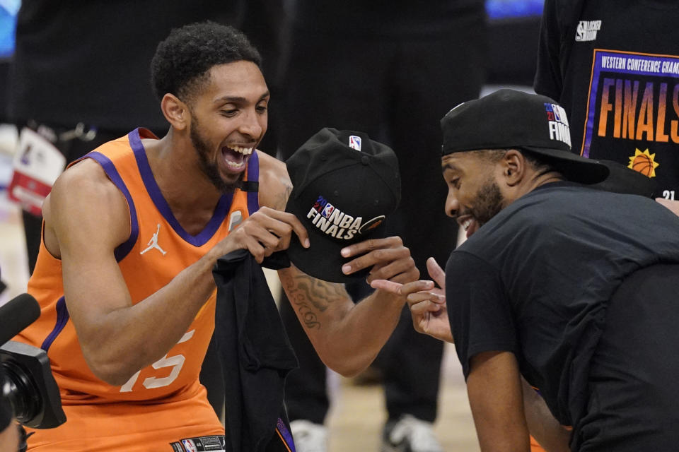 Phoenix Suns guard Cameron Payne, left, celebrates with forward Mikal Bridges after the Suns won Game 6 of the NBA basketball Western Conference Finals against the Los Angeles Clippers Wednesday, June 30, 2021, in Los Angeles. The Suns won the game 130-103 to take the series 4-2. (AP Photo/Mark J. Terrill)