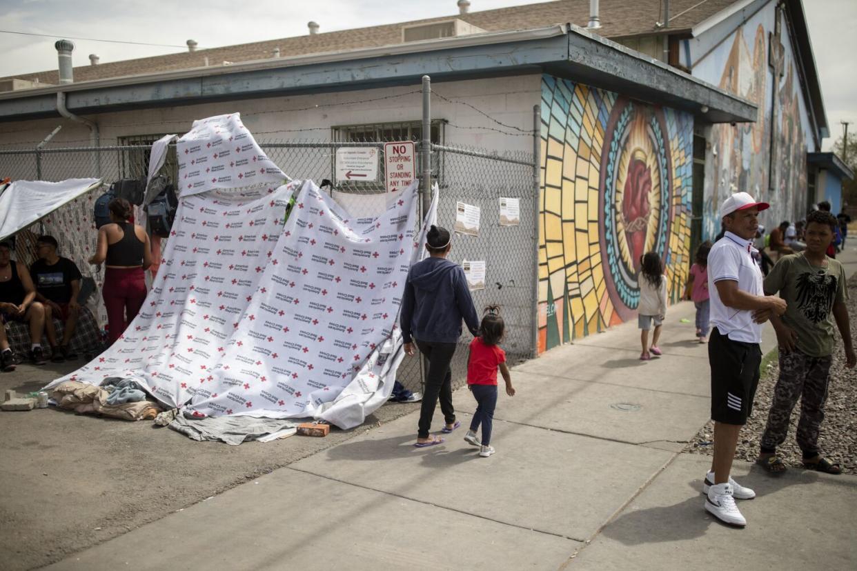 A group of migrants in the alley outside the makeshift migrant shelter at Sacred Heart Church in El Paso.