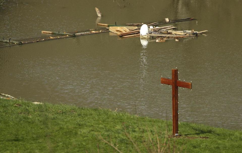 A newly constructed cross is shown Monday, March 31, 2014, at the edge of floodwaters next to the home of Don and Elaine Young near Darrington, Wash. The home sits just out of the debris field of the the massive mudslide that hit the nearby community of Oso,Wash. on March 22, 2014, but the property was affected by floodwaters from the baked up Stillaguamish River. (AP Photo/Ted S. Warren)