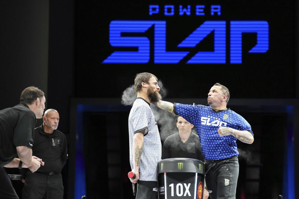 In this photo provided by Zuffa LLC , Travis Aragon slaps Jon Kennedy at a Power Slap event in Rio De Janiero, Brazil, Nov. 30, 2022. Power Slap fights are typically three to five rounds. The fighters take turns hitting each other in the face with an open hand, and those on the receiving end stand with their hands behind their backs. (Mike Roach/Sciaffo LLC via AP)