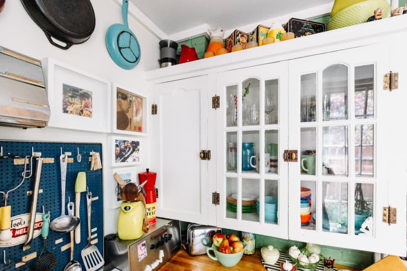 Kitchen with white cabinets with glass cutouts.