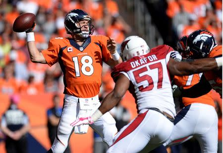 Oct 5, 2014; Denver, CO, USA; Denver Broncos quarterback Peyton Manning (18) looks to pass in the second quarter against the Arizona Cardinals at Sports Authority Field at Mile High. Mandatory Credit: Ron Chenoy-USA TODAY Sports