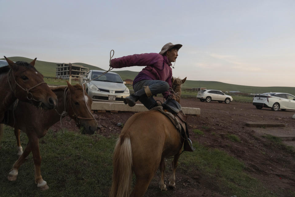 A Mongolian horseman leaps onto his horse on the outskirts of Ulaanbaatar, Mongolia, Monday, July 1, 2024. (AP Photo/Ng Han Guan)