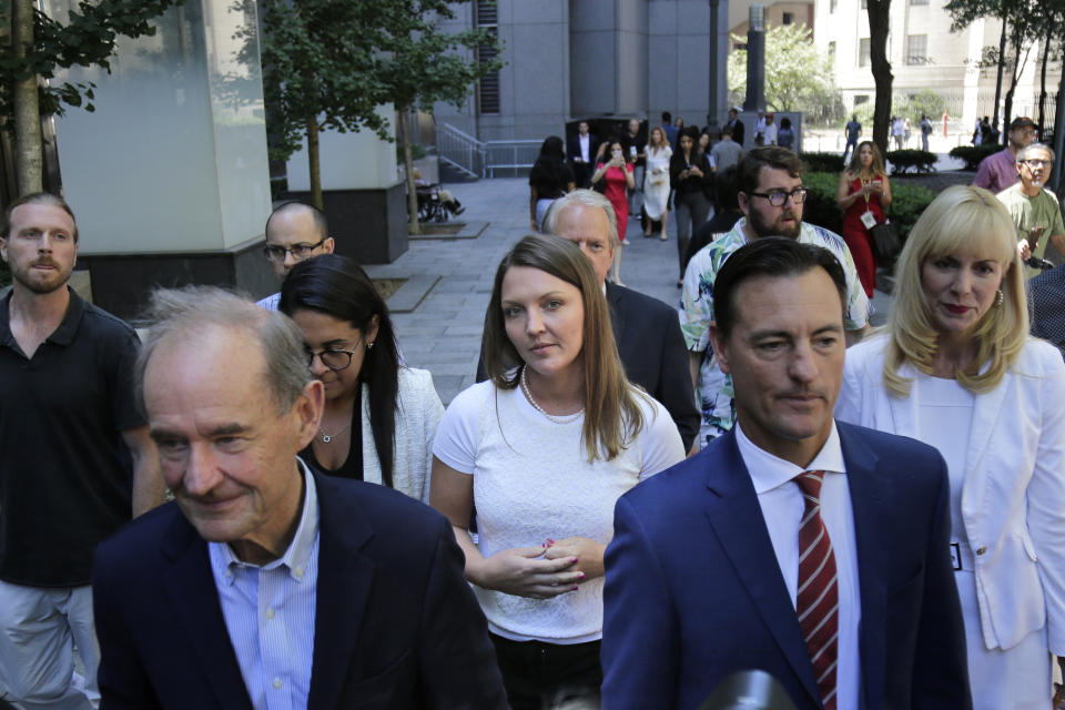 Courtney Wild, center, an alleged victim of Jeffery Epstein, leaves the courthouse in New York, Monday, July 15, 2019. Financier Jeffrey Epstein will remain behind bars for now as a federal judge mulls whether to grant bail on charges he sexually abused underage girls. (AP Photo/Seth Wenig)
