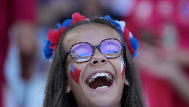 A spectator laughs as she waits for the start of the Rugby World Cup Pool D match between Samoa and Chile at the Stade de Bordeaux in Bordeaux, France, Saturday, Sept. 16, 2023.