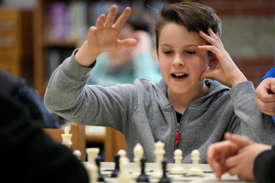 Eli Marquis, a Reeds brook Middle school student, reacts during an after-school chess team match, Tuesday, April 25, 2023, in Hampden, Maine. Part-time chess coach and full-time custodian David Bishop led his elementary and middle school teams to state championship titles this year.