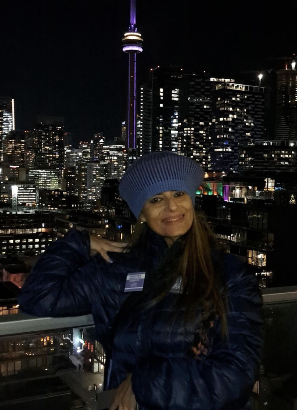 Tiano posing with the CN Tower, which was lit periwinkle in support of Stomach Cancer Awareness Day, which is celebrated every November 30th. (Image used with permission Instagram/mygutfeeling.ca)