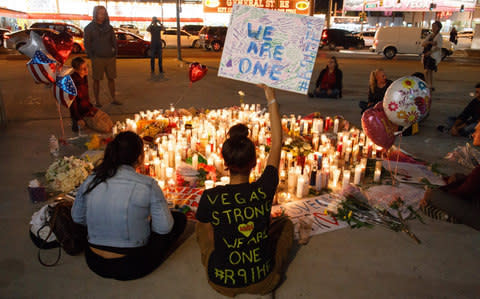 Mourners pay tribute to Paddock's victims at a makeshift memorial on the Las Vegas Strip on October 2 - Credit: EPA/EUGENE GARCIA