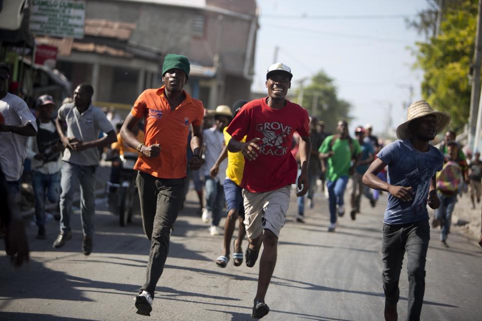 Supporters of presidential candidate Maryse Narcisse run from national police during their protest against final election results in Port-au-Prince, Haiti, Tuesday, Jan. 3, 2017. An electoral tribunal certified the presidential election victory of first-time candidate Jovenel Moise. (AP Photo/Dieu Nalio Chery)