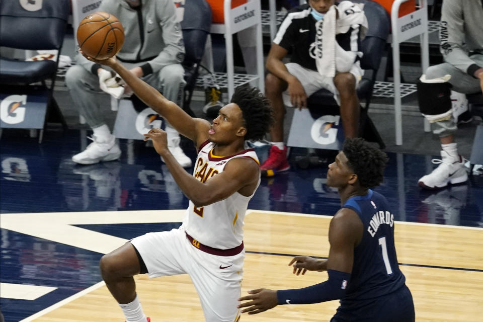 Cleveland Cavaliers' Collin Sexton (2) lays up as Minnesota Timberwolves' Anthony Edwards (1) looks on in the first half of an NBA basketball game Sunday, Jan. 31, 2021, in Minneapolis. (AP Photo/Jim Mone)