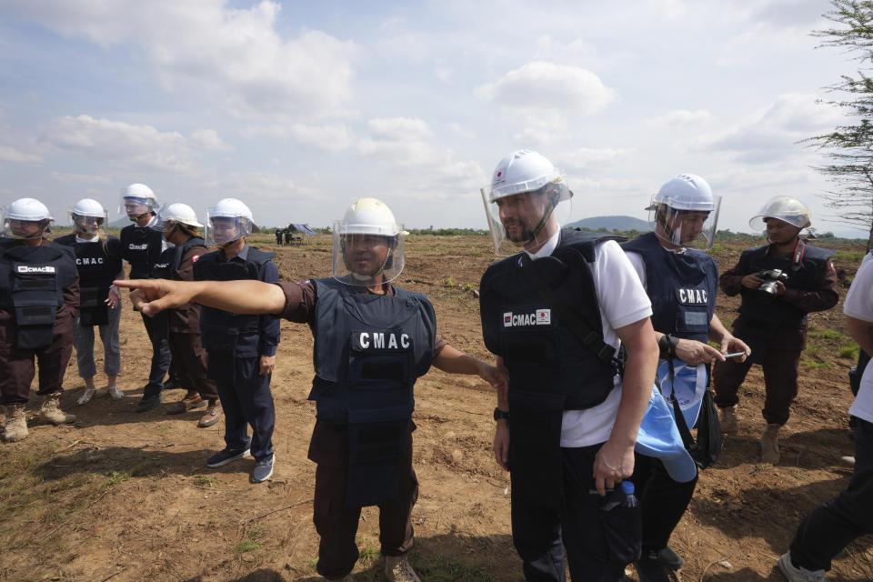 A Ukrainian deminer, front right, listens to a Cambodia Mine Action Center, CMAC, demining expert, front left, at a minefield in Preytotoeung village, Battambang province, Cambodia, Thursday, Jan. 19, 2023. Cambodian experts, whose country has the dubious distinction of being one of the world's most contaminated by landmines, walked a group of Ukrainian soldiers through a minefield being actively cleared Thursday, hoping their decades of experience will help the Europeans in their own efforts to remove Russian mines at home. (AP Photo/Heng Sinith)