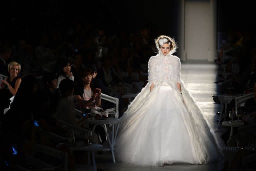 US model Lindsey Wixson presents a creation by Chanel during the Haute Couture Fall-Winter 2012-2013 collections shows in Paris. Bohemian belles in feathers and sparkling faux-tweed glided past the white wicker tables of an old world spa as Chanel put its own spin on the vintage craze at the Paris haute couture shows on Tuesday