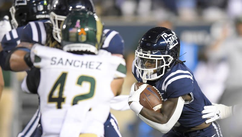 Utah State running back Davon Booth, right, carries the ball for a 22-yard touchdown against Colorado State during the first half of an NCAA college football game Saturday, Oct. 7, 2023, in Logan, Utah. 
