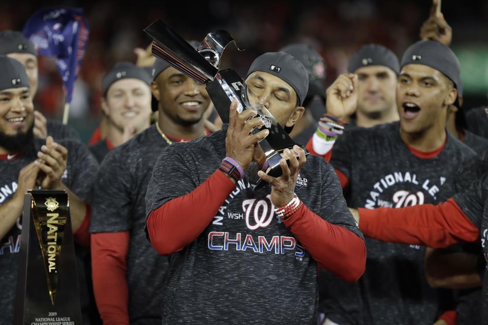 Washington Nationals manager Dave Martinez kisses the NLCS trophy after Game 4 of the baseball National League Championship Series against the St. Louis Cardinals Tuesday, Oct. 15, 2019, in Washington. The Nationals won 7-4 to win the series 4-0. (AP Photo/Jeff Roberson)