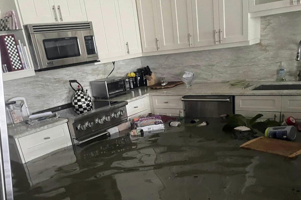 This image provided courtesy of Heather Donlan and posted on social media, shows flooding from Hurricane Ian in her father's home in Naples, Fla. Donlan said her social media post crowdsourced the person she holds responsible for saving her father's life as flooding inundated the 87-year-old's home. (Courtesy of Heather Donlan via AP)