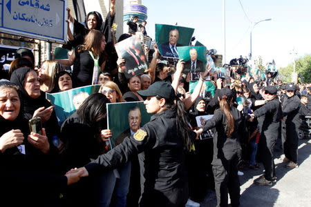 Kurdish mourners hold pictures of former Iraqi president Jalal Talabani in Sulaimaniya, Iraq, October 6, 2017. REUTERS/Ako Rasheed