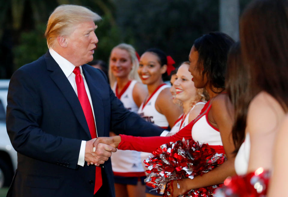<p>U.S. President Donald Trump greets cheerleaders with the Florida Atlantic University Marching Band before hosting a Super Bowl LII watch party at Trump International Golf Club in Palm Beach, Florida U.S., February 4, 2018. REUTERS/Leah Millis </p>