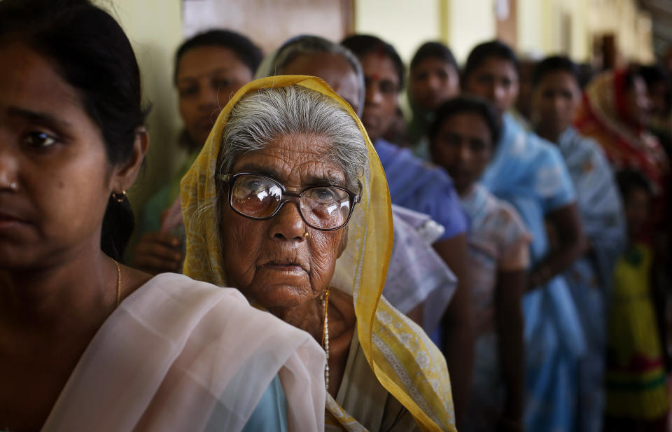 An elderly Indian woman watches as she stands in a queue to cast her vote during the first phase of elections in Dibrugarh, in the northeastern state of Assam, India, Monday, April 7, 2014. (AP Photo/Altaf Qadri)