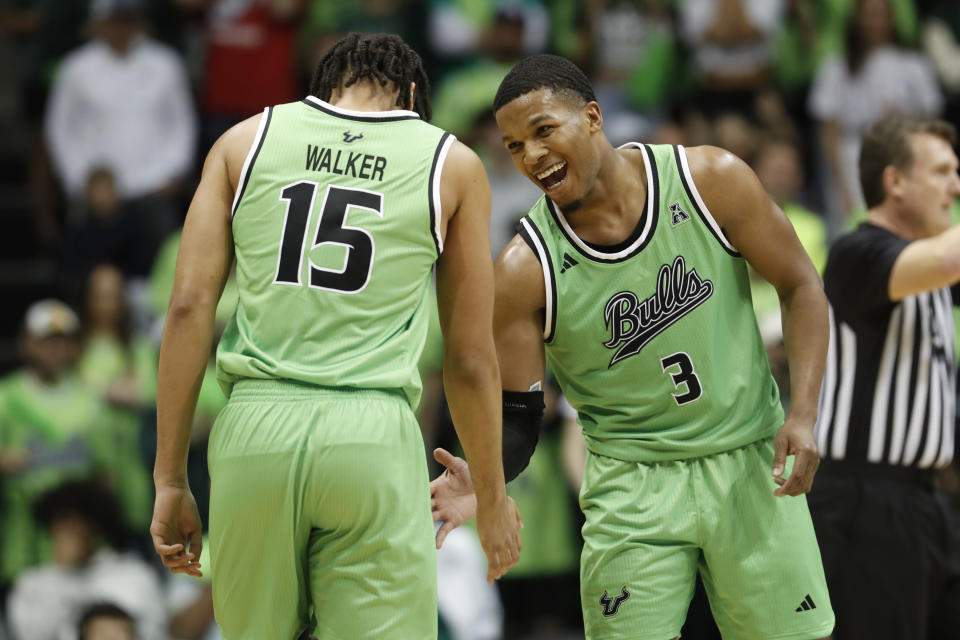 South Florida guard Chris Youngblood (3) celebrates with teammate Corey Walker Jr. (15) during the second half of an NCAA college basketball game against Florida Atlantic, Sunday, Feb. 18, 2024, in Tampa, Fla. (AP Photo/Scott Audette)