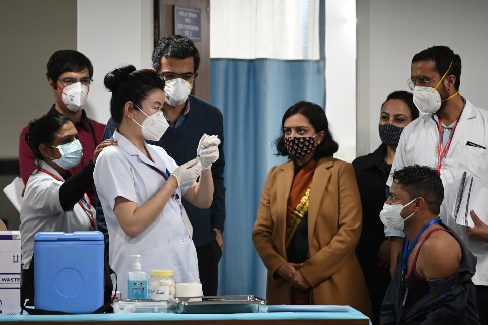 A medical worker prepares to inoculate a colleague with a Covid-19 coronavirus vaccine at the All India Institute of Medical Science (AIIMS) in New Delhi in January 16, 2021. (Photo by Sajjad HUSSAIN / AFP) (Photo by SAJJAD HUSSAIN/AFP via Getty Images)