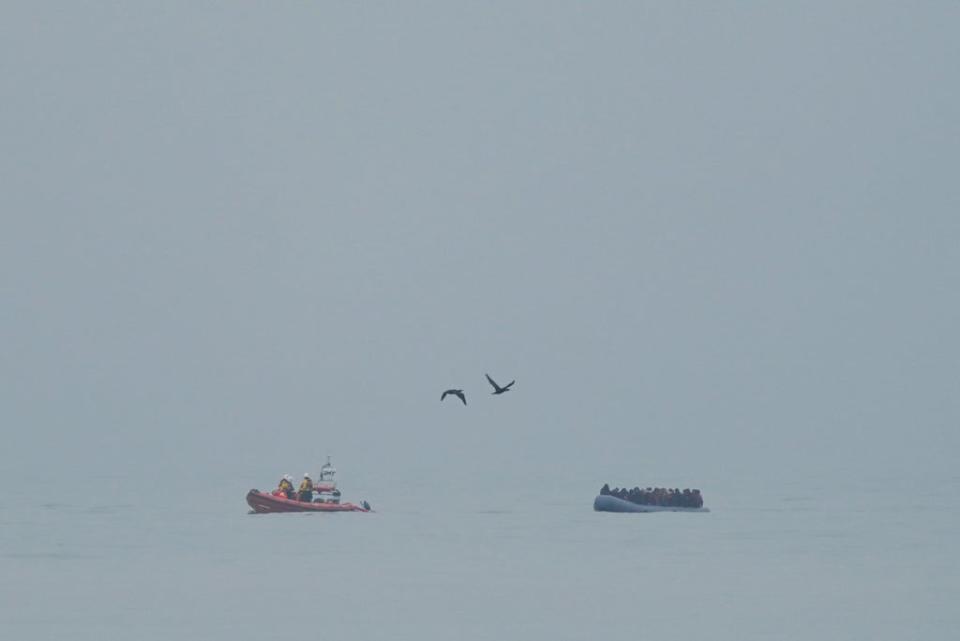 File picture of a lifeboat escorting a dinghy carrying people thought to be migrants (PA Wire)