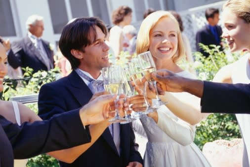 Bride and groom drinking with guests at wedding reception