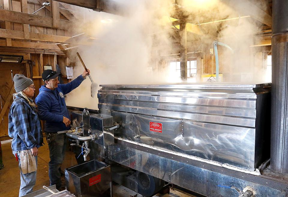 Kiristin Brubach and Jon Britton check the progress of the maple syrup as they boil it to extract the maple syrup in the Malabar Farm Sugar Shack Tuesday, Feb. 21, 2023. TOM E. PUSKAR/ASHLAND TIMES-GAZETTE