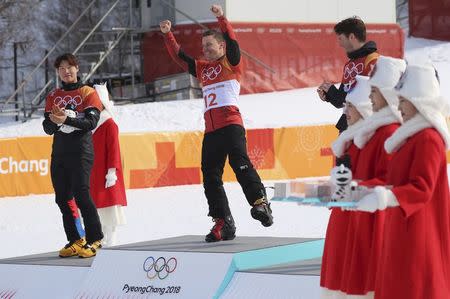 Freestyle Skiing - Pyeongchang 2018 Winter Olympics - Men's Parallel Giant Slalom Finals - Phoenix Snow Park - Pyeongchang, South Korea - February 24, 2018 - Gold medallist Nevin Galmarini Of Switzerland flanked by silver medallist Lee Sang-ho of South Korea and bronze medallist Zan Kosir Of Slovenia celebrates during flower ceremony. REUTERS/Mike Blake