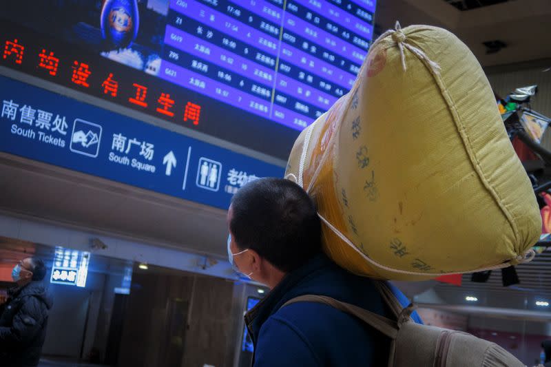 Traveller carries his belongings at a railway station in Beijing