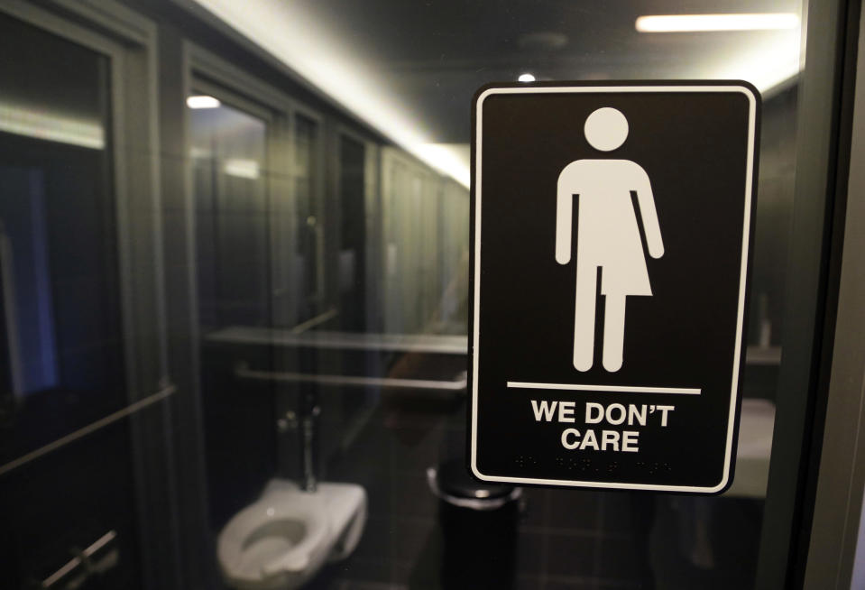 FILE - In this May 12, 2016 file photo, signage hangs outside a restroom at 21c Museum Hotel in Durham, N.C. A federal judge approved a legal settlement Tuesday, July 23, 2019 affirming transgender people's right to use restrooms matching their gender identity in many North Carolina public buildings. (AP Photo/Gerry Broome, File)