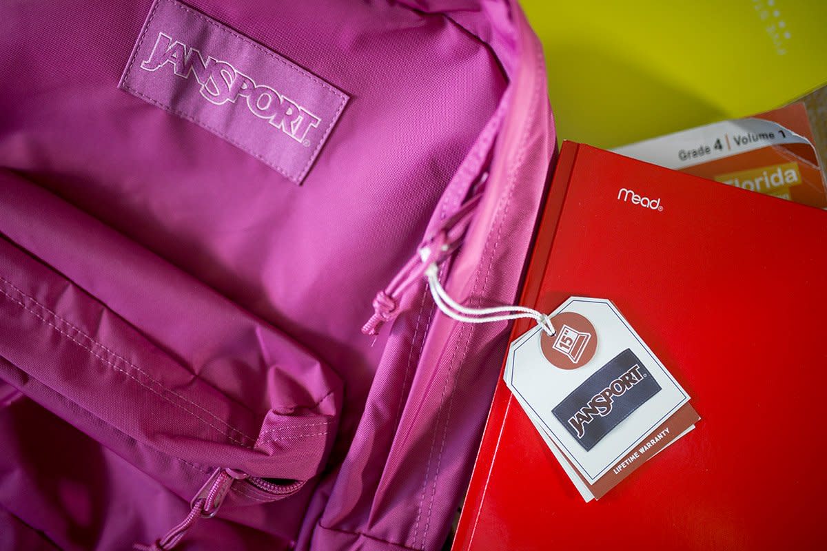 A photograph shows a backpack and some notebooks.