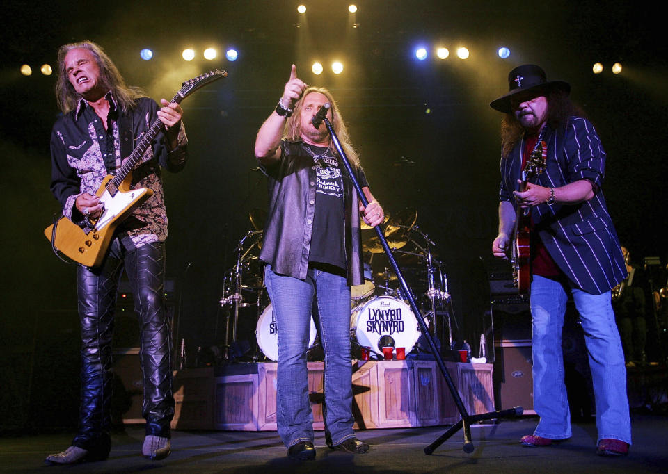 FILE - Lynyrd Skynyard lead singer Johnny Van Zant, center, appears with guitarists Rickey Medlocke, left, and Gary Rossington during a performance in Nashville, Tenn., on May 27, 2005. Rossington, the iconic band's last surviving cofounder, who died Sunday, March 5, was also perhaps the last flag pole in a once powerful part of American culture: Southern rock. (AP Photo/John Russell, file)