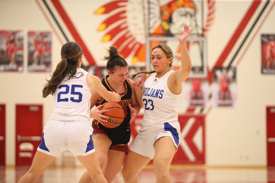 McCutcheon sophomore Aubrey Miller (center) runs into the double team of Bishop Chatard sophomore Betsy Tragesser (left) and senior Quinn Johnson (right) during the Twin Lakes Holiday Classic championship on Thursday, Dec. 28, 2023.