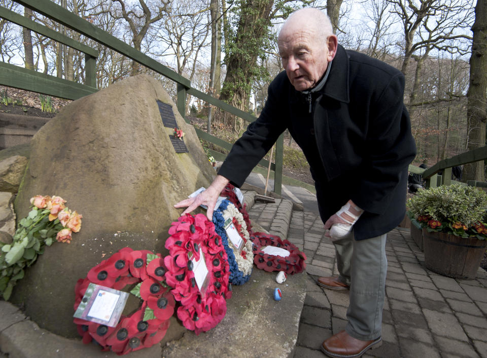 Tony Foulds tends to a memorial honouring 10 U.S. airmen who died in a plane crash in Endcliffe Park, Sheffield, England, Wednesday, Feb. 13, 2019. Foulds was just a kid running around in the park on Feb. 22, 1944 when a U.S. Air Force crew decided to crash and die rather than take the chance of hitting them. He's dreamed of honoring them for decades. Now he's 82 and about to get his wish. (AP Photo/Rui Vieira)