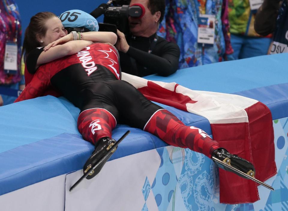 Charles Hamelin of Canada, right, embraces Marianne St. Gelais after he won the men's 1500m short track speedskating final at the Iceberg Skating Palace during the 2014 Winter Olympics, Monday, Feb. 10, 2014, in Sochi, Russia. (AP Photo/Ivan Sekretarev)