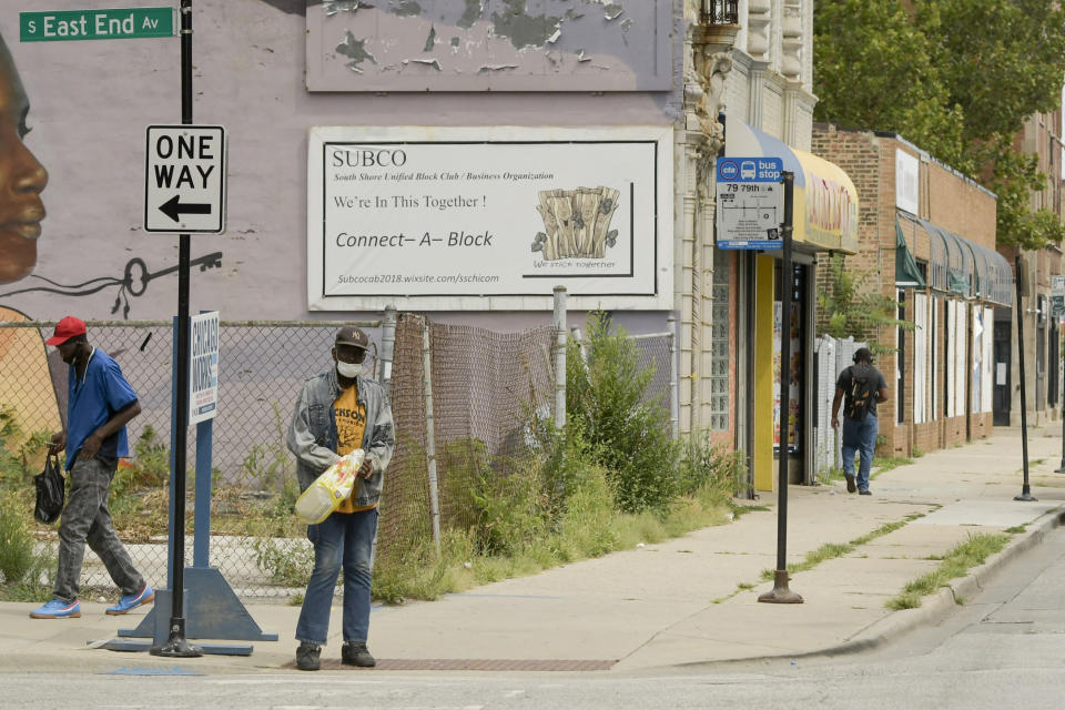 Paint peels from buildings and weeds grow in empty lots along East 79th Street in Chicago on Friday, Aug. 13, 2021, in a neighborhood on the South Side near where the shooting of Safarian Herring took place in May 2020. (AP Photo/Mark Black)