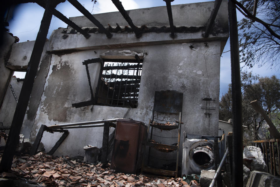 A burned house stands in Acharnes suburb, on Mount Parnitha, in northwestern Athens, Greece, Sunday, Aug. 27, 2023. More than 600 firefighters, including reinforcements from several European countries, backed by a fleet of water-dropping planes and helicopters were battling three persistent major wildfires in Greece Sunday, two of which have been raging for days. (AP Photo/Michael Varaklas)