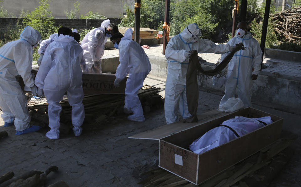 Health workers and relatives carry the body of a COVID-19 victim for cremation in Jammu, India, Monday, May 24, 2021. India crossed another grim milestone Monday of more than 300,000 people lost to the coronavirus as a devastating surge of infections appeared to be easing in big cities but was swamping the poorer countryside. (AP Photo/Channi Anand)