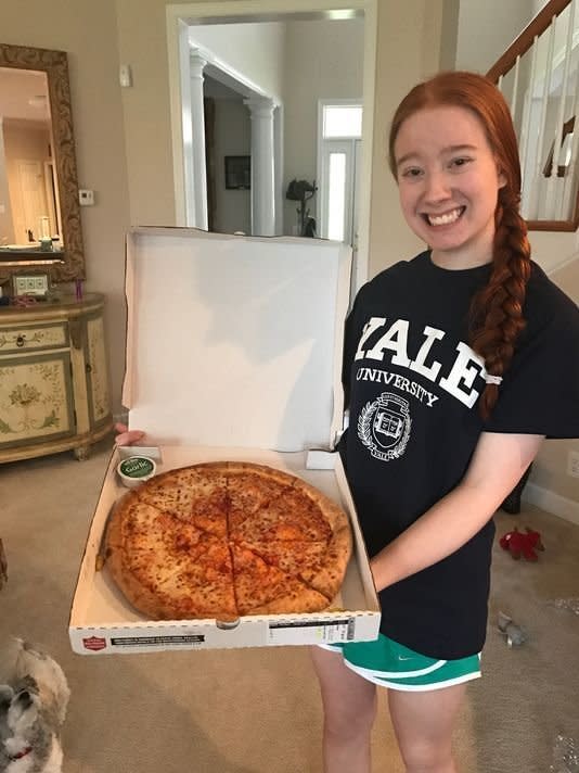 Recent high school graduate Carolina Williams, 18, holds up a Papa Johns pizza after getting accepted into Yale University. (Photo: Carolina Williams)