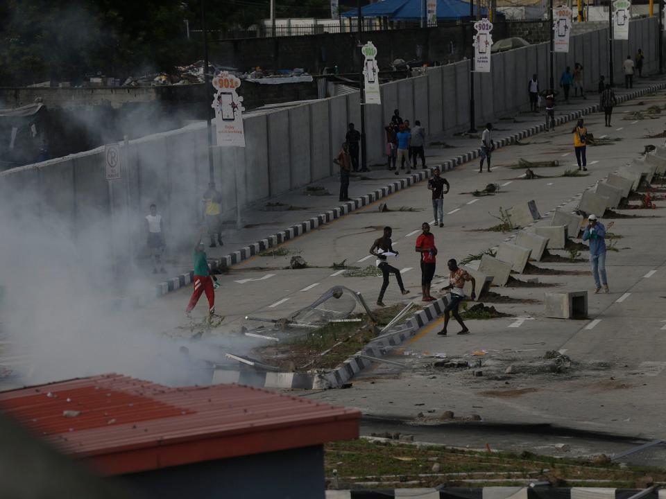 Protesters at Lekki toll gate in Lagos on Wednesday as police officers deploy teargasAP