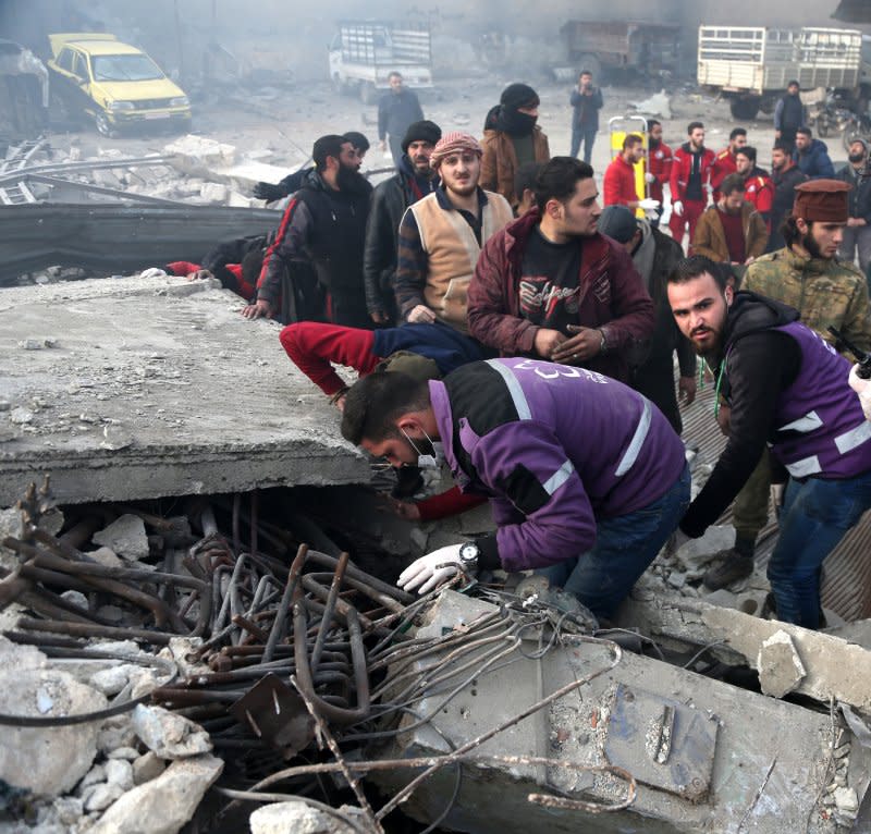 Rescuers search for survivors under the rubble of a collapsed building at the site of airstrike targeting the center in the industrial area in the east of Idlib, Syria, in 2020. File Photo by Yahya Nemah/EPA-EFE